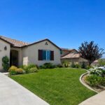 Single-story tile-roof home on a Beaumont, California street, with open hills in the distance
