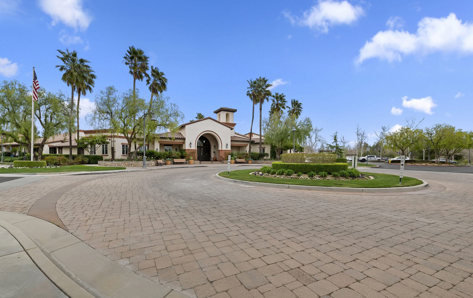 The Lodge clubhouse exterior with palms and flagpole at Four Seasons at Beaumont