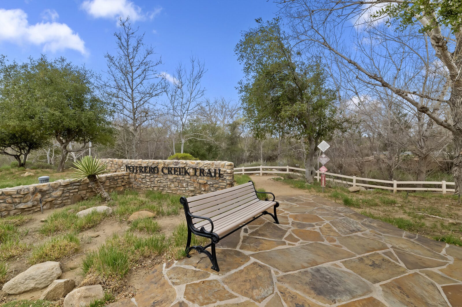 Noble Creek Trail head with bench and flagstone paving at Four Seasons at Beaumont