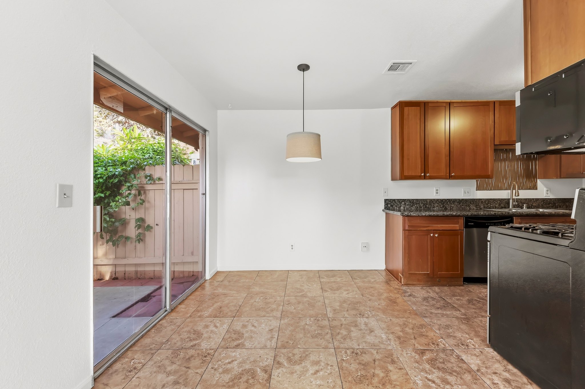 Dining area with pendant light and slider to the private patio | 1194 Border Ave #A, Corona