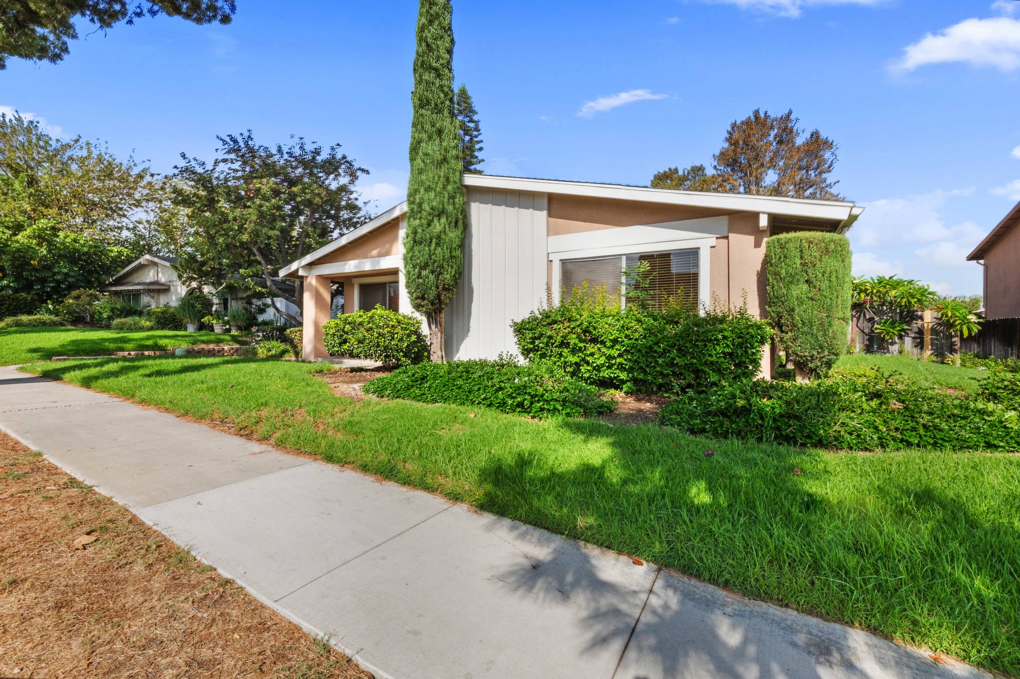 Front exterior of the single-story end-unit condo with lawn and walkway | 1194 Border Ave #A, Corona