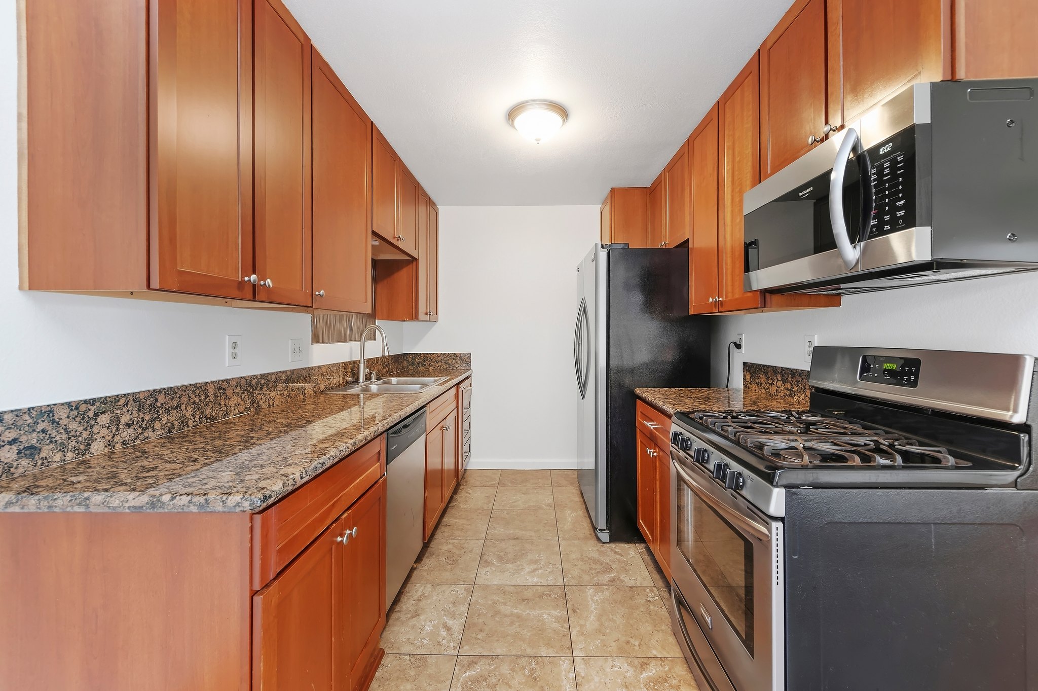 Kitchen with stainless gas range, microwave and refrigerator | 1194 Border Ave #A, Corona