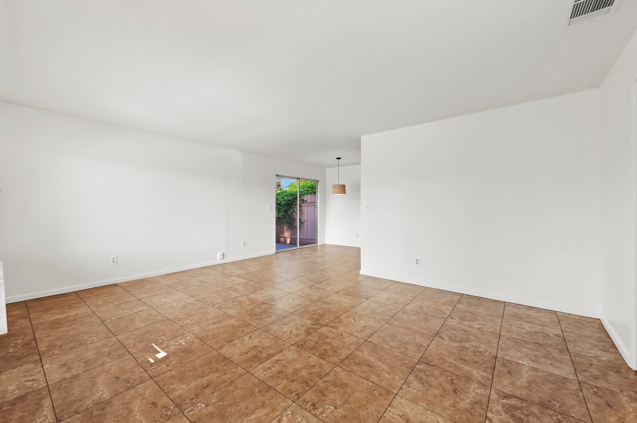 Open living room with tile floors and slider to the patio | 1194 Border Ave #A, Corona