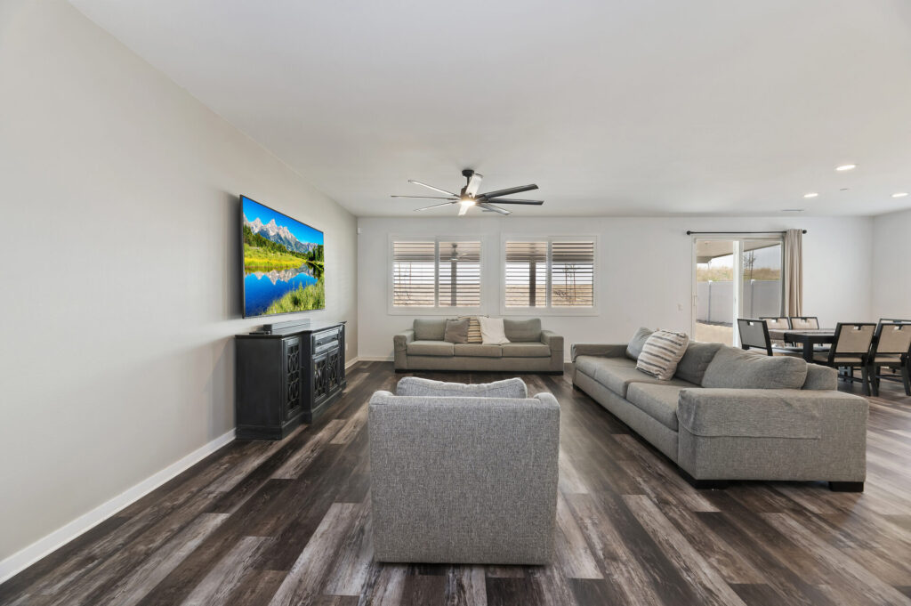 Living room with ceiling fan and window shutters