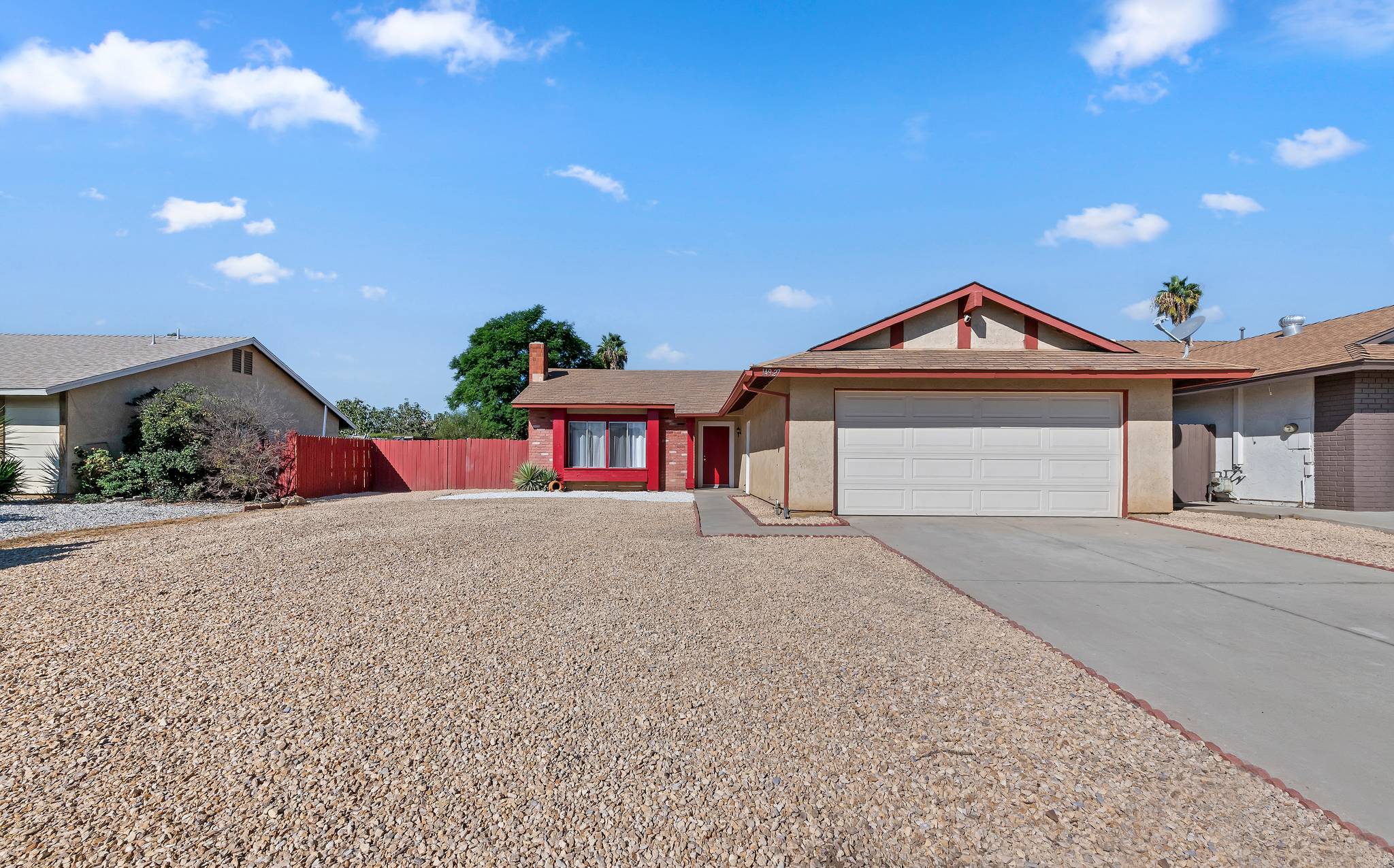 Front of the single-story home with a 2-car garage and low-maintenance rock landscaping | 14927 Wintergreen St, Moreno Valley