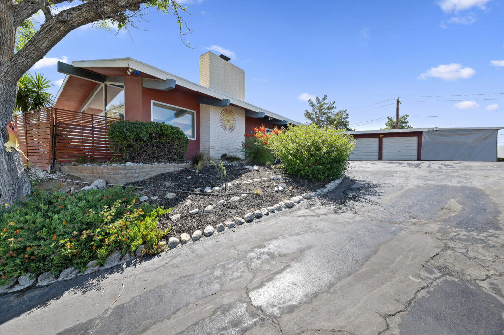 1717 Terrace Dr, Hemet — front of the home with brick chimney, landscaped beds and driveway