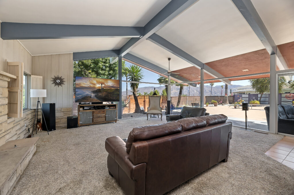 1717 Terrace Dr, Hemet — living room with exposed beams, stone fireplace and window wall