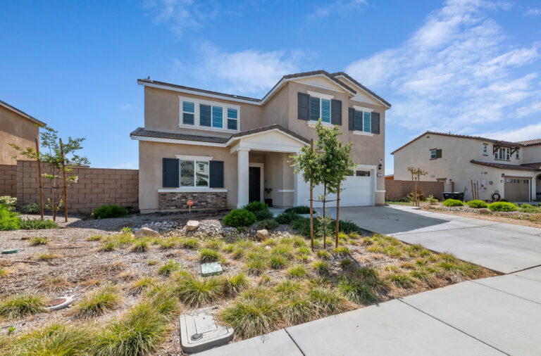 2153 El Nido Ave, Perris — front of the two-story home with two-car garage and drought-tolerant front yard