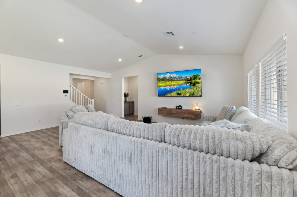 2153 El Nido Ave, Perris — living room with vaulted ceiling, recessed lighting and wood-look flooring