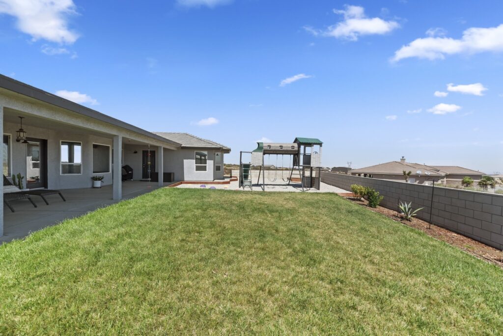 7122 Braceo St, Oak Hills — fenced backyard with lawn and play area